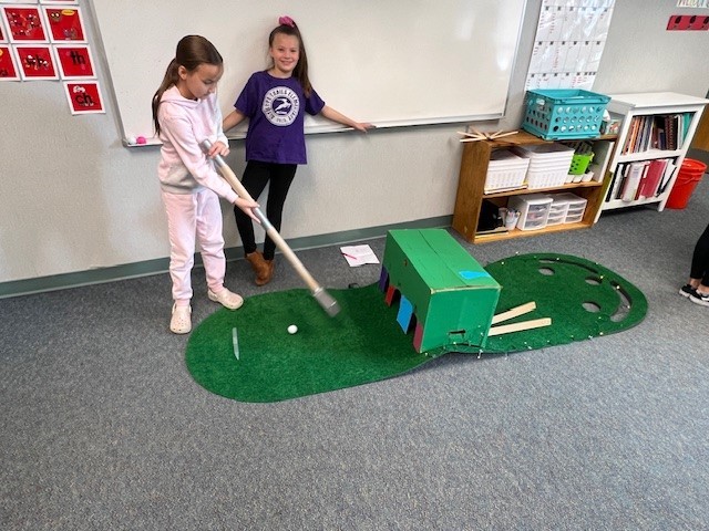 Students playing a cardboard game.