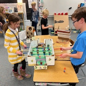 Students playing a cardboard game.