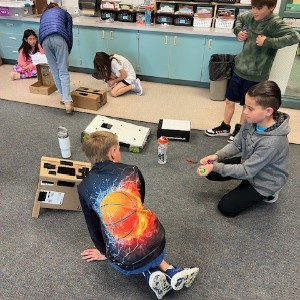 Students playing a cardboard game.