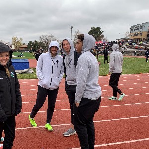 Students wearing hoodies, enduring chilly weather, at the track meet