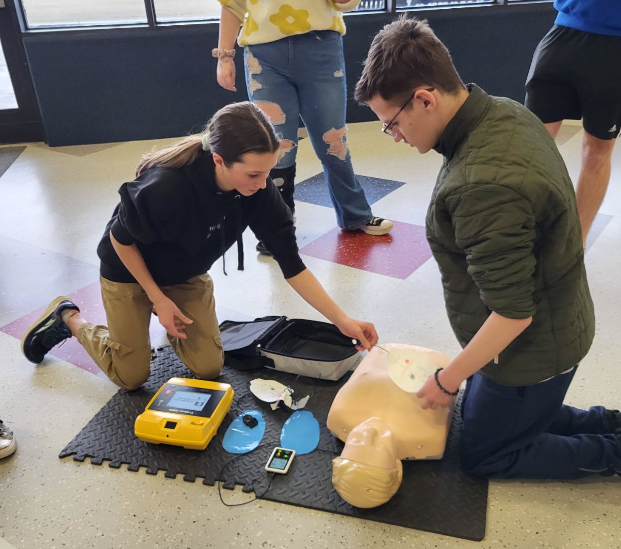 Two Liberty students use an AED (automated external defibrillator) on a manikin during a training course at Liberty High School.