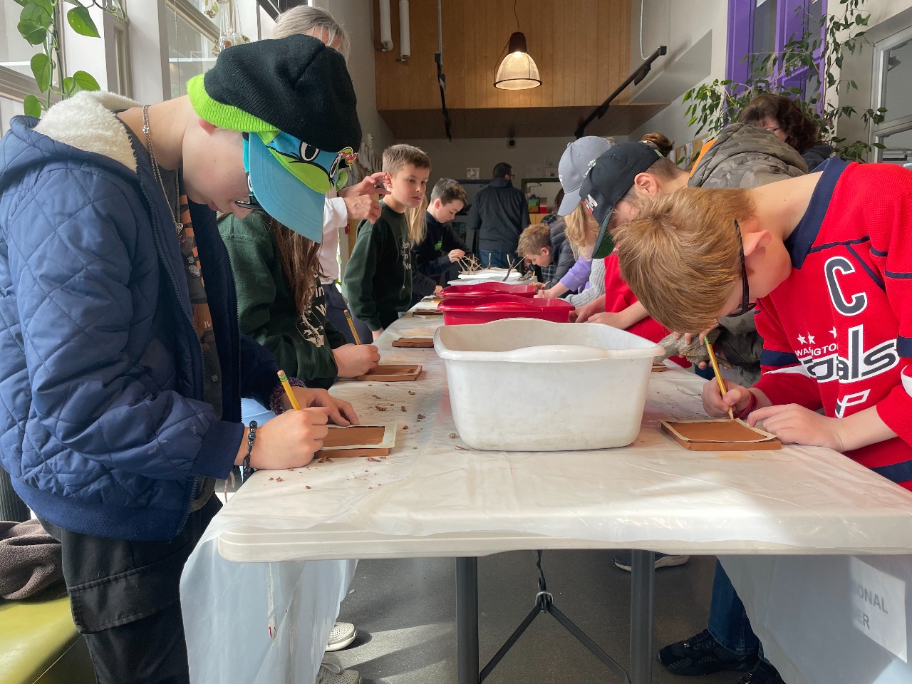 Students at School in the Woods working on tile projects during art class.