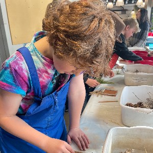 Student at School in the Woods working on tile projects during art class.