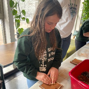 Student at School in the Woods working on tile projects during art class.