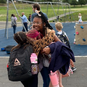 Friends embrace in a hug on the playground.