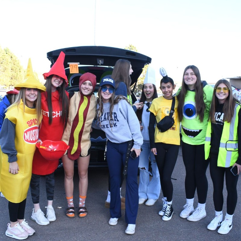 Trunk or Treat 2022: Students dresses as ketchup, mustard, a hotdog, and characters from Monster's Inc.