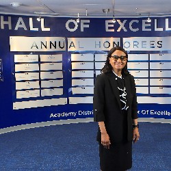 Dr. Mary Thurman poses in front of Hall of Excellence