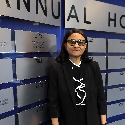 Dr. Mary Thurman poses in front of Hall of Excellence