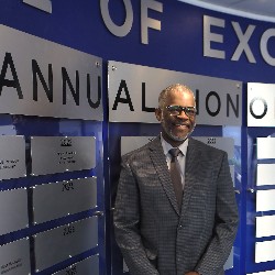 MSgt. Rush poses in front of Hall of Excellence