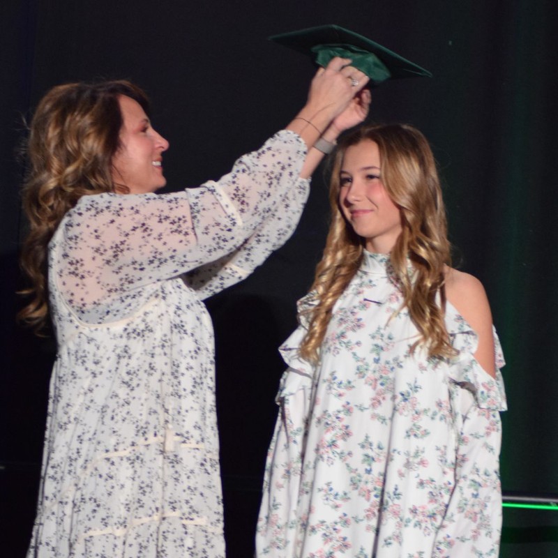 Mom places graduation cap on her daughter's head