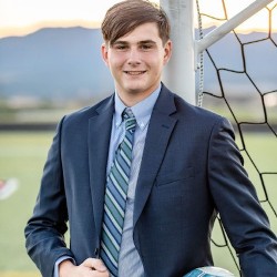 Student wearing suit in front of soccer goal