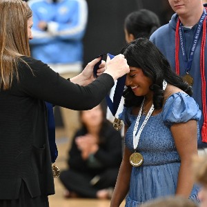 Teacher putting medal over student's head