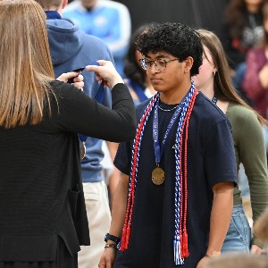 Student preparing to have medal put around his neck