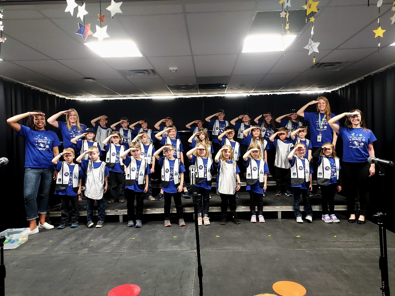 Students and teachers saluting.