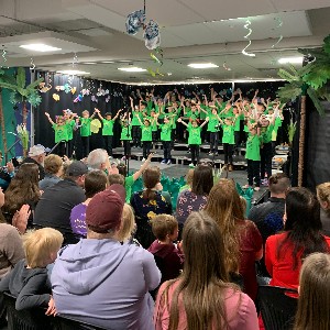 Students singing with hands in the air.