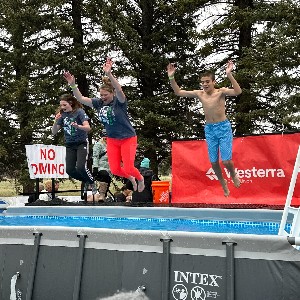 Students jumping in outdoor pool