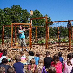 A teachers speaks to students outside a garden