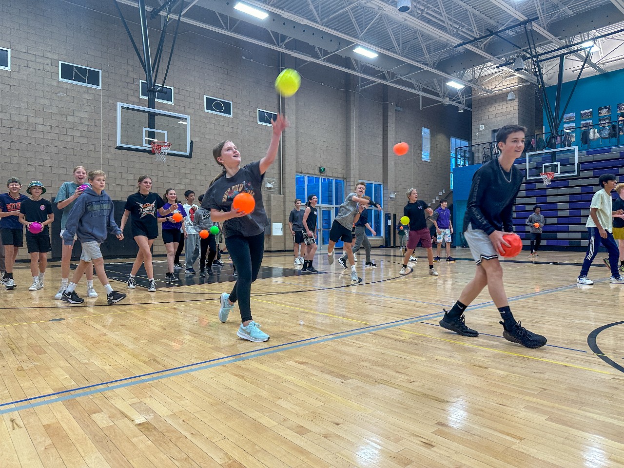 students throw dodgeballs