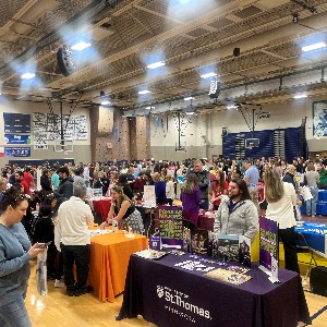 Students touring college information tables in the Gym