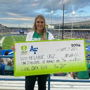 Melanie Cruz, Douglass Valley Elementary School teacher smiles with a large check