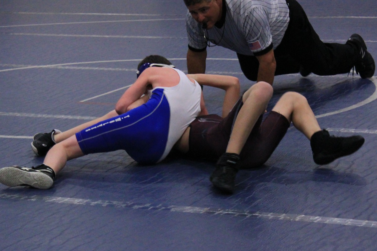 A TMS wrestler on the mat during a competition.