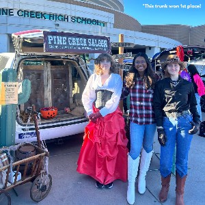 Students in front of a trunk decorated like a western.