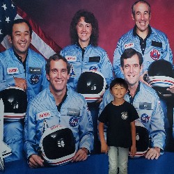 Student standing in front of a photo of astronauts