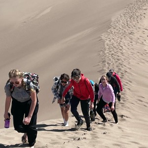 Photo from Rodney Pierson of students climbing the sand dunes