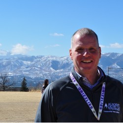 Brian Wright smiles on the MRMS playground, with the front range in the background.
