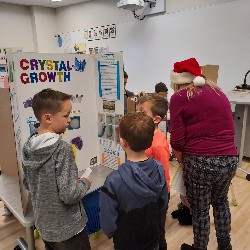 Students and staff looking at science fair project