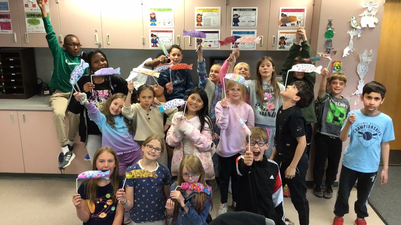 Students holding decorated fish.