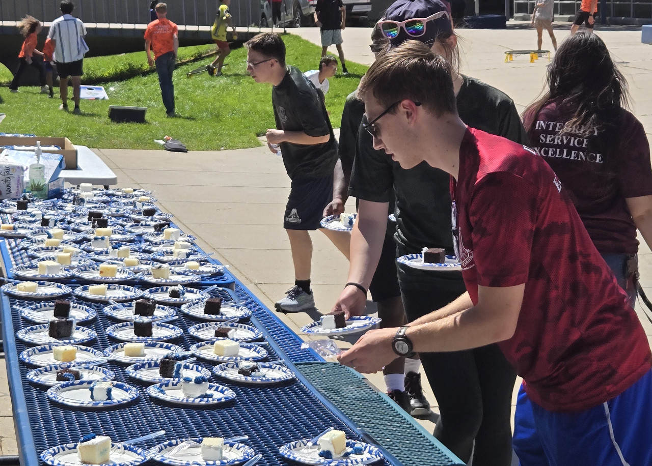 ROTC cadet hands out birthday cake. 