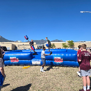 Two students play games at the picnic while other studetns watch. 