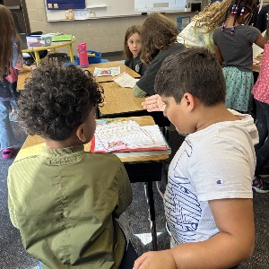 4th grade student helping his buddy with an assignment.