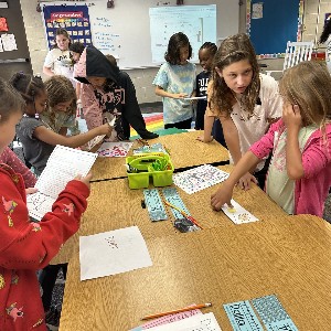 5th grade students making a craft with 2nd grade students