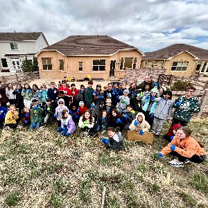 5th graders pick up along the fence.