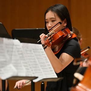 Student playing violin in concert