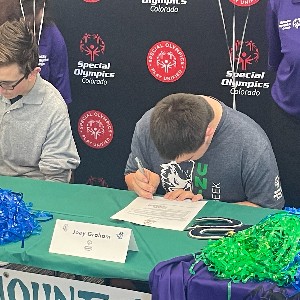 Two students signing a paper