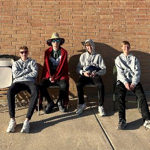 Boys seated by brick wall