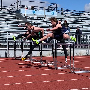 Athletes jump hurdles