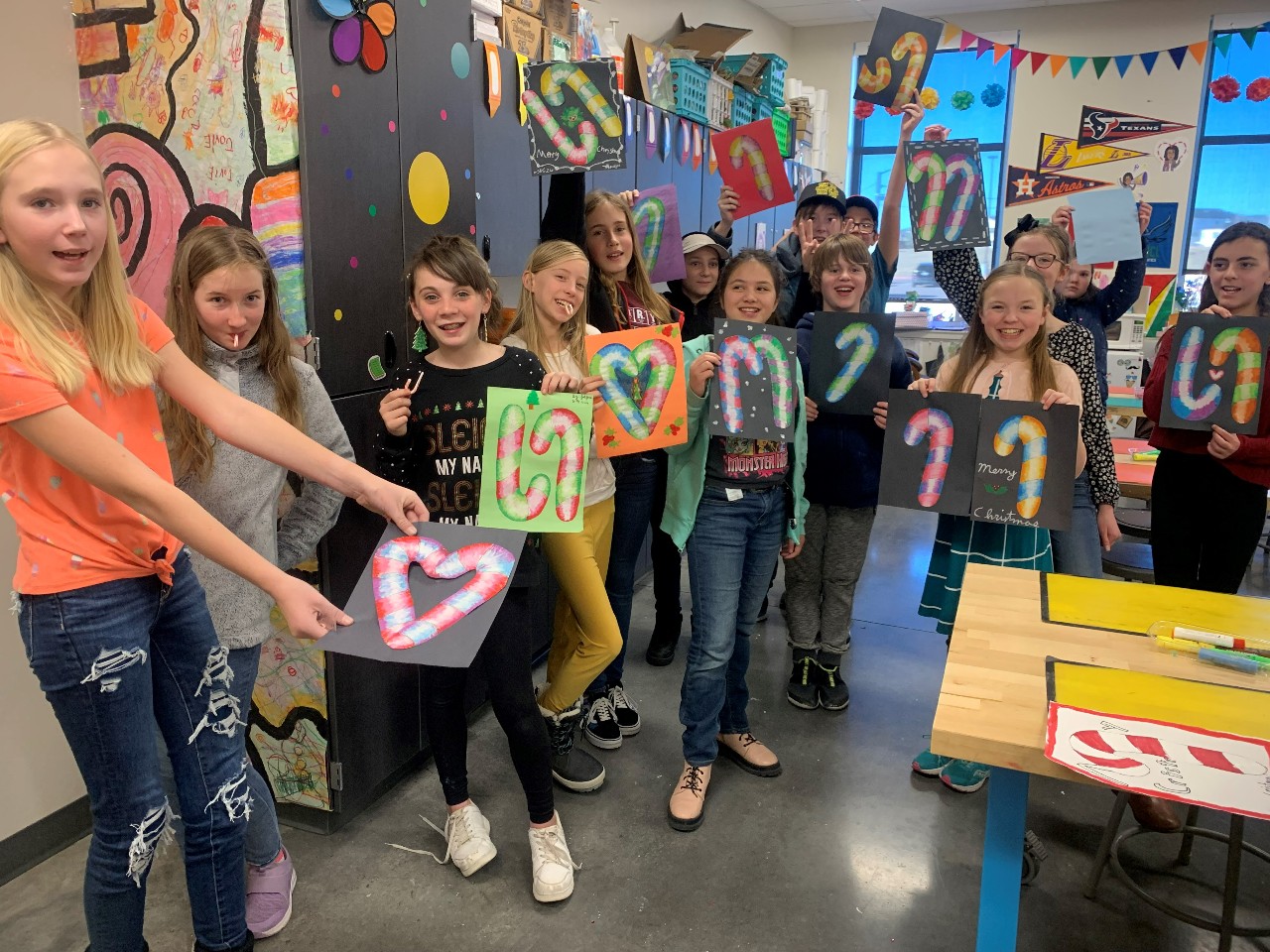 Students holding up artwork of candy canes