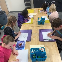 Students drawing a dragon eye