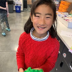 Students holding clay creation.