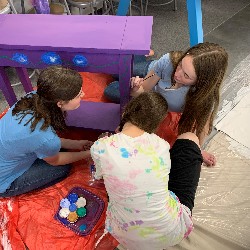 Students painting a table.