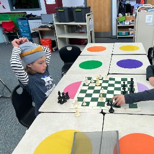 Students playing chess in a library.