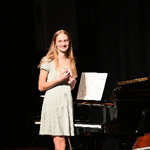 Student standing by piano