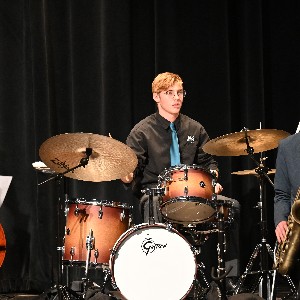 Drummer sitting behind a drum set