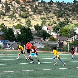 Offense and defensive students run a flag football play.