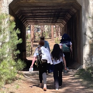 Students walking under a bridge to find the next clue
