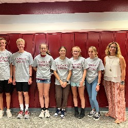 Students wearing the Eagleview Athletics t-shirts stand with Mrs. White in front of lockers.